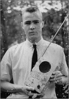 The author, in a vintage photograph, showing his home-brew, cigar-box transistor radio.